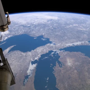 a satelight floats over the planet earth directly above the great lakes